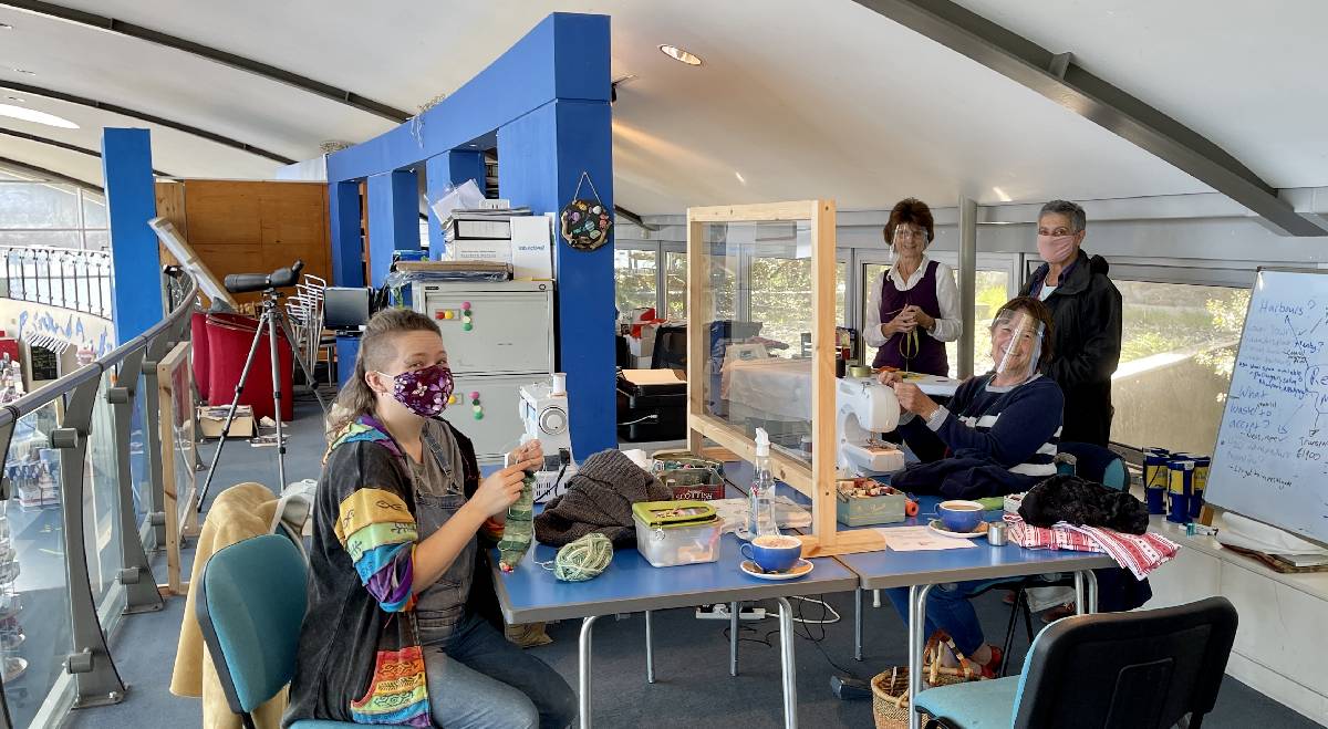 Photo of TBG volunteers repairing clothes with sewing machines, at Ocean Lab in Goodwick